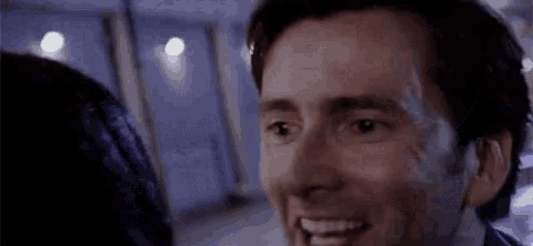 a man is smiling while looking at a woman .
