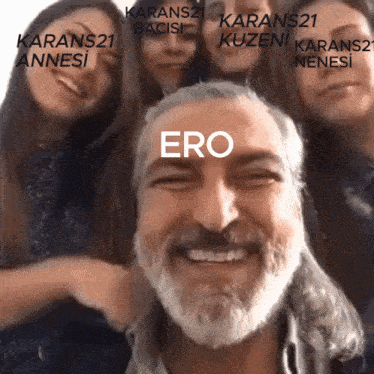 a man with a beard is smiling in front of a group of people and the word ero is on his face