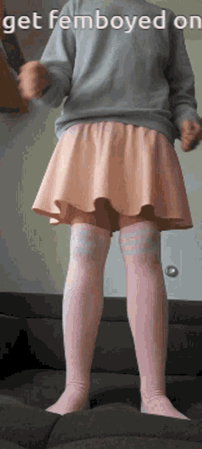 a person wearing a pink skirt and pink socks is standing on a couch