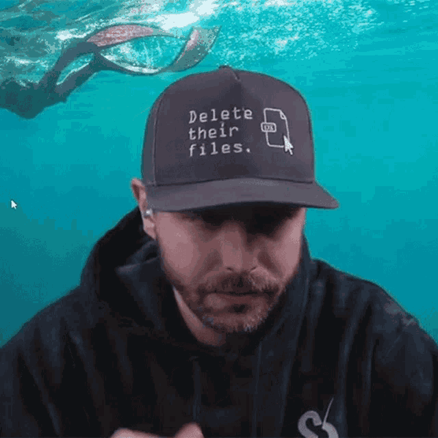 a man wearing a baseball cap that says delete their files