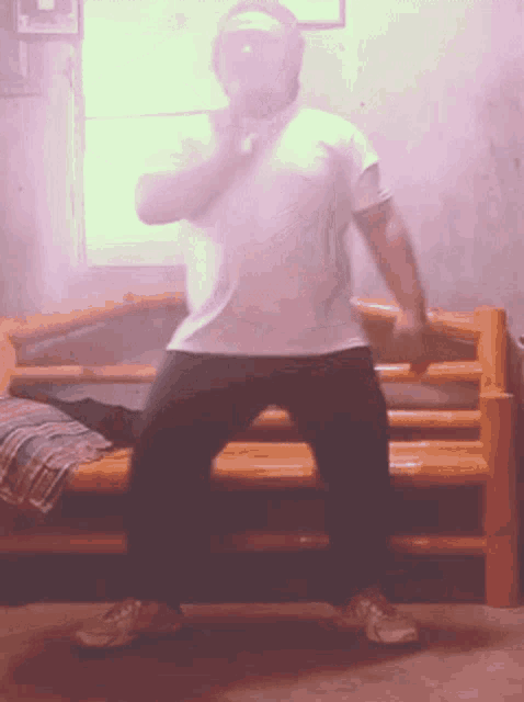 a man in a white shirt and black pants is standing in front of a wooden bench