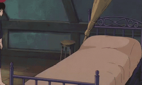 a girl in a purple dress is standing next to a bed