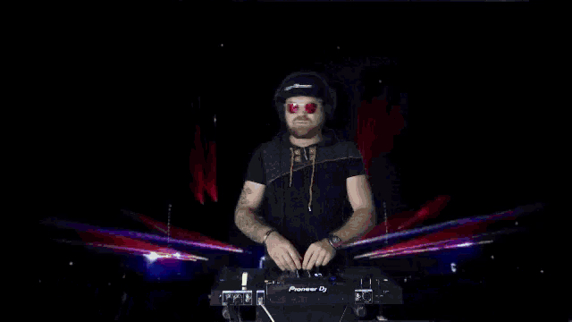 a man wearing headphones and sunglasses playing a pioneer dj