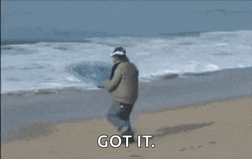 a person is riding a wave on a beach and the words `` got it '' are visible .