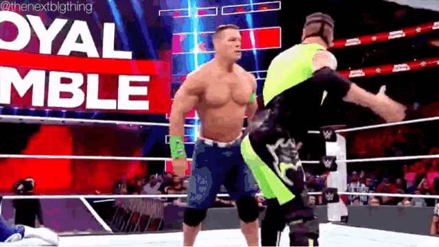 two men are wrestling in a ring with the words royal rumble in the background .