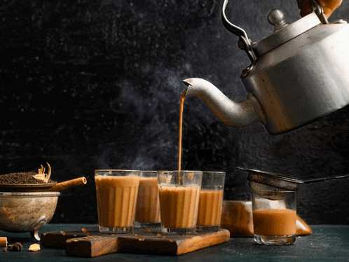 tea is being poured into a glass from a kettle