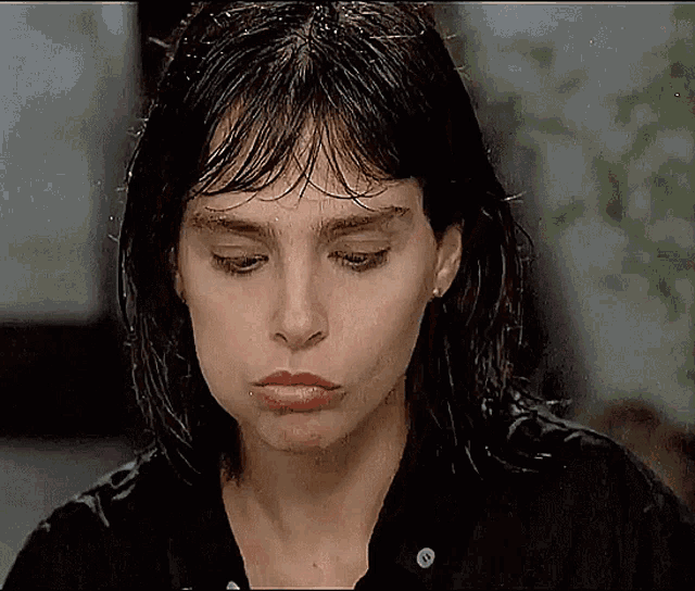 a close up of a woman 's face with her eyes closed and her hair wet