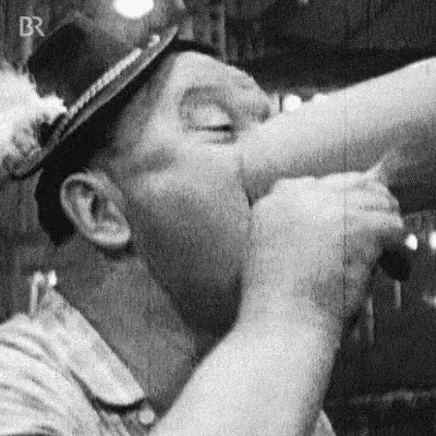 a black and white photo of a man wearing a hard hat and a helmet .