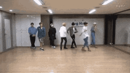 a group of young men are dancing in a room with big hit entertainment written on the wall