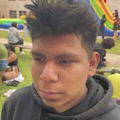 a young man with a hoodie on looks at the camera