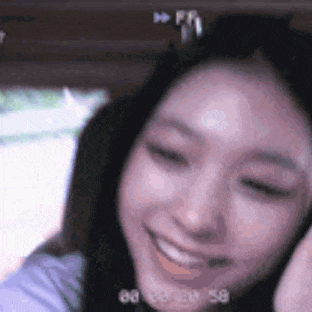 a close up of a woman 's face smiling and looking at the camera while taking a selfie .