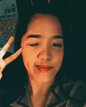 a girl giving a peace sign in front of a sign that says ' cottager ' on it
