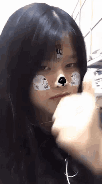a girl with a sticker on her face that looks like a bear .