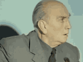 a man in a suit and tie is giving a speech .