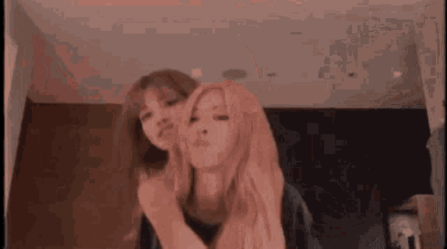 a couple of women are standing next to each other in a room and making funny faces .