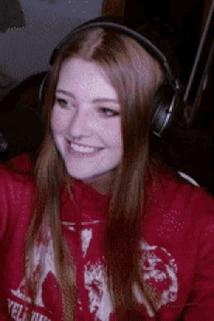 a woman wearing headphones and a red sweatshirt that says ' yello ' on it