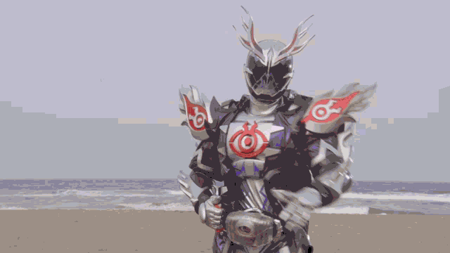 a robot is standing on a sandy beach in front of a building