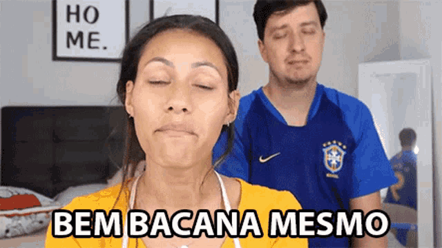 a woman with her eyes closed is standing next to a man who is wearing a soccer jersey with the word brasil on it