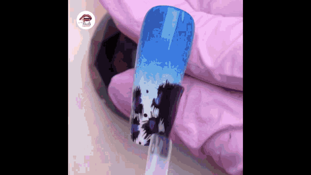 a close up of a person 's nails with blue and black paint