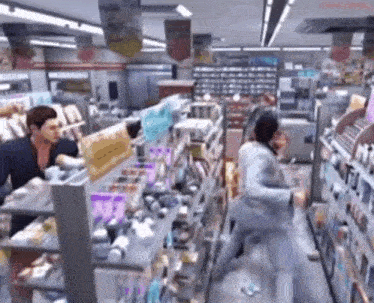 a man is standing in a store with a sign that says ' a ' on it