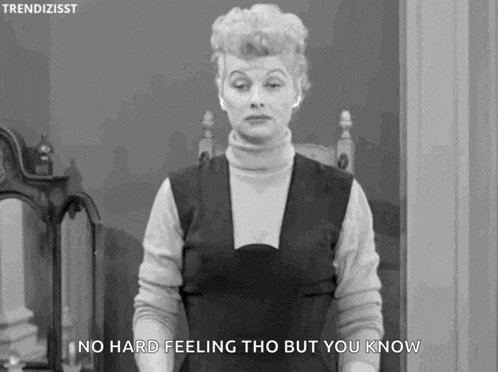 a woman is standing in front of a mirror and saying `` no hard feeling tho but you know '' in a black and white photo .