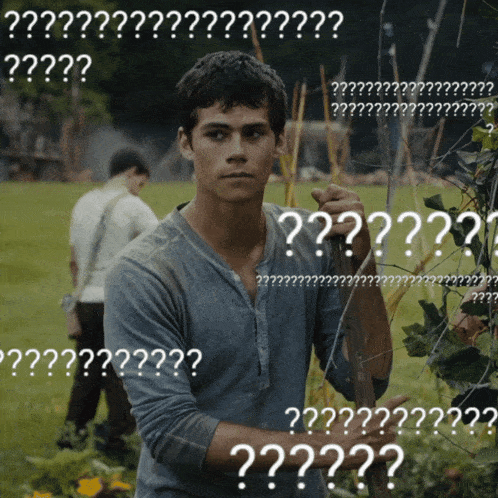 a man standing in a field with a bunch of white letters that say ' ?? '