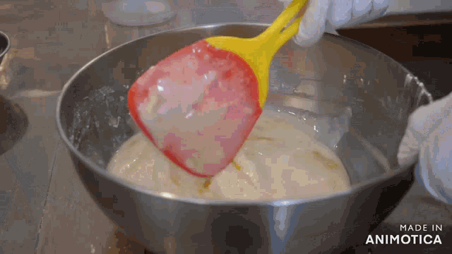 a person is mixing something in a bowl with a spatula and the words made in animotica are visible