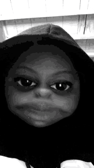 a black and white photo of a person wearing a hooded sweatshirt