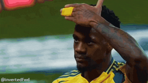 a man in a yellow shirt has a yellow band on his forehead