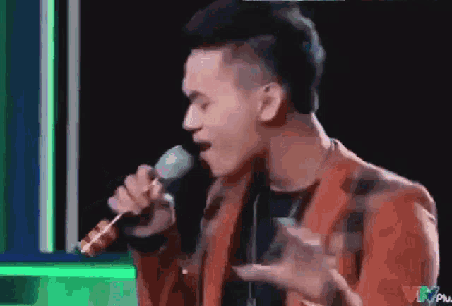 a man singing into a microphone with the words bang bang bang written on the bottom