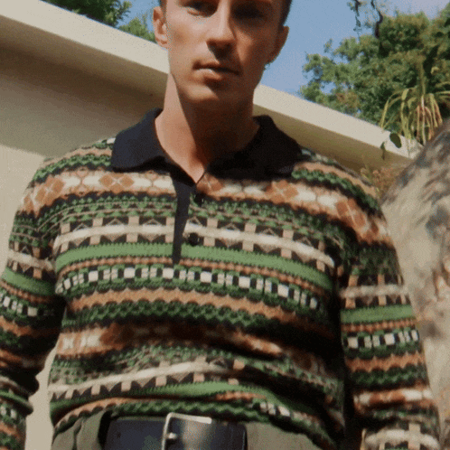 a man wearing a sweater with a geometric pattern on it