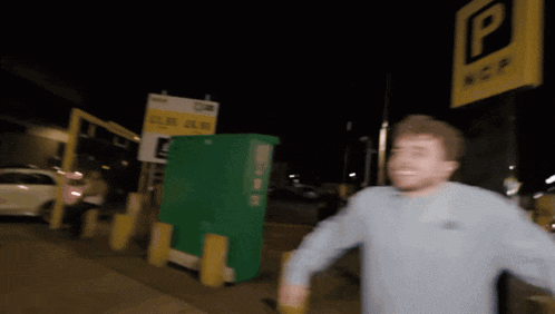 a blurry picture of a man walking in front of a parking sign that says ncp