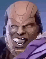 a close up of a man 's face with a helmet on and his tongue out .