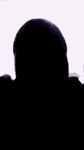 a silhouette of a man 's head is visible in a dark room .