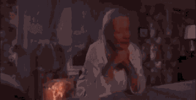 a blurry picture of a woman sitting on a bed in front of a window in a room .