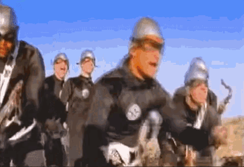 a group of soldiers wearing helmets and goggles are running in a line .
