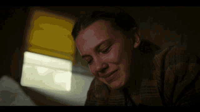 a close up of a woman 's face with a yellow blind in the background