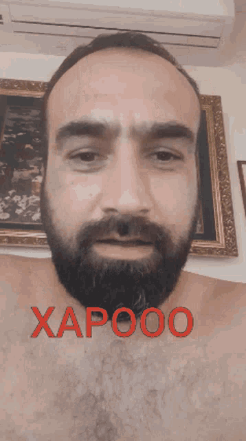 a shirtless man with a beard has the word xapooo written on his face
