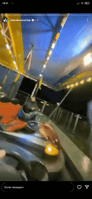 a person is riding a bumper car at a carnival and the time is 19:41