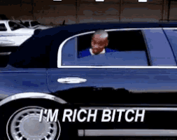 a man is sitting in a car that says i 'm rich bitch on the side