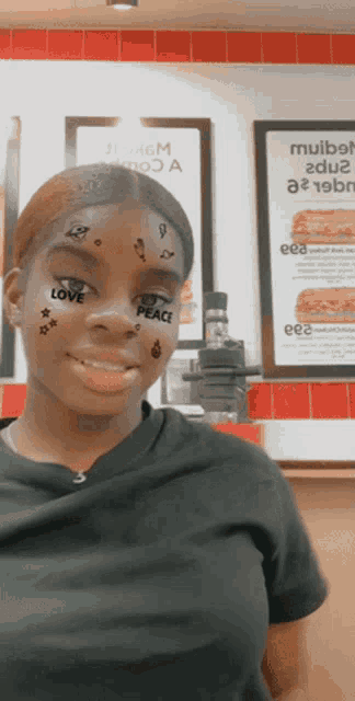 a girl with stickers on her face that say love peace