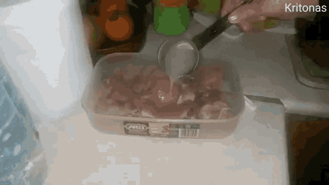 a person is pouring liquid into a container that says milo on it