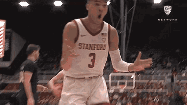 a stanford basketball player with the number 3 on his jersey celebrates