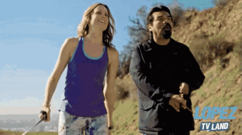 a man and a woman are walking down a hill with the tv land logo in the background