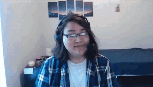 a woman wearing glasses and headphones is sitting in a room .
