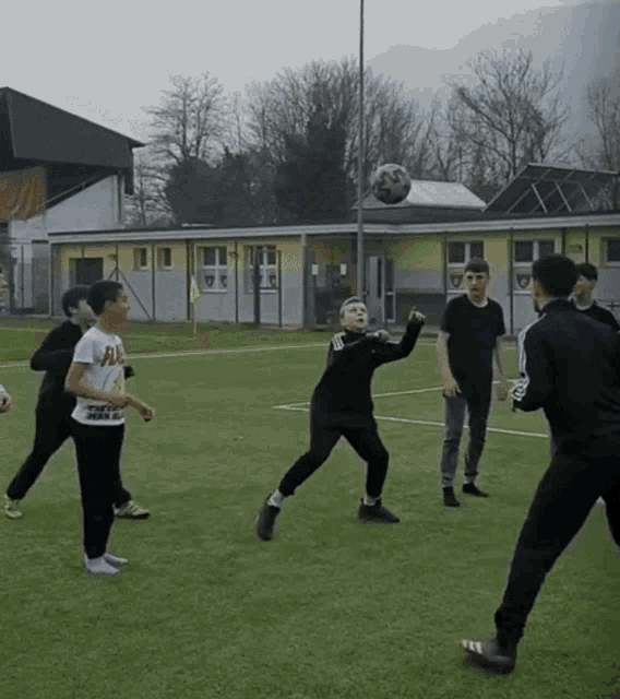 a boy wearing a t-shirt that says " all " throws a soccer ball
