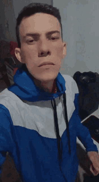 a young man in a blue and white adidas jacket