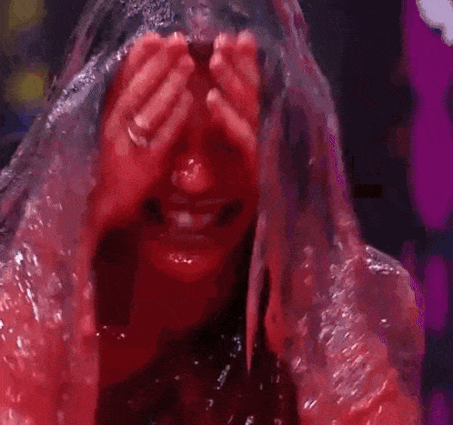 a woman is covered in red slime and is smiling .