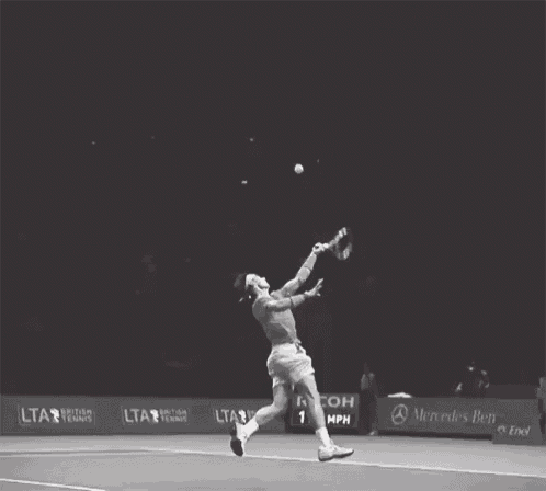 a tennis player is swinging a racket on a court with mercedes benz advertisements
