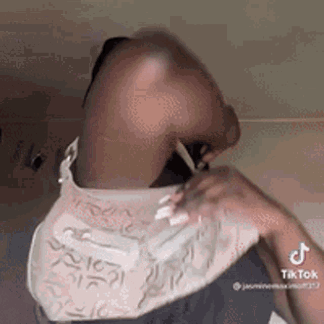 a woman is sitting on a bed with her arms outstretched and a purse on her back .